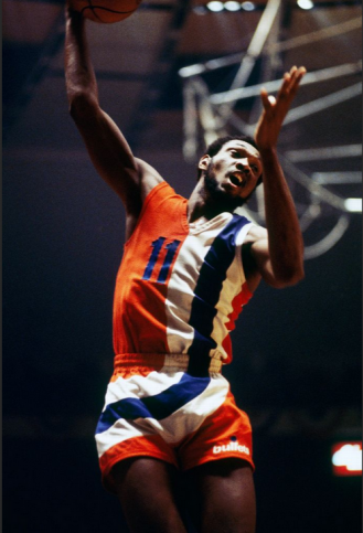 Here we have one of the most unusual uniforms in NBA history! The super-prominent striping makes it easy to miss the most radical aspect of the design, which is that neither the team name nor the city name appears on the jersey for the Washington Bullets.