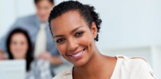 image Smiling businesswoman saving money in a piggy-bank